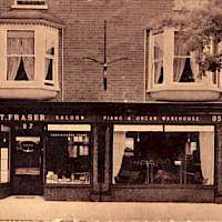 TitleCard showing premises of T. Fraser, music saloon, piano and organ warehouse, in Harpur Street. Mr Chrystal notes that Thomas Fraser opened his shop at 87 Harpur Street about 1901 and by 1913 had extended to include numbers 85 & 89, as well as changing the name to Fraser & Son. No indication of publisher. Card is unused.Date free textc.1909Production dateFrom: 1909 To: 1909
Scope and ContentPrinted on reverse of card 'The Visit of the King to Wrest Park. Extract from the Beds. Times July 30 1909. 'Mr T. Fraser, 85 and 87 Harpur Street, Bedford, had the honour of tuning the organ in the church and the pianos at the Park'