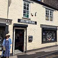 A white painted shop on a sloping street.